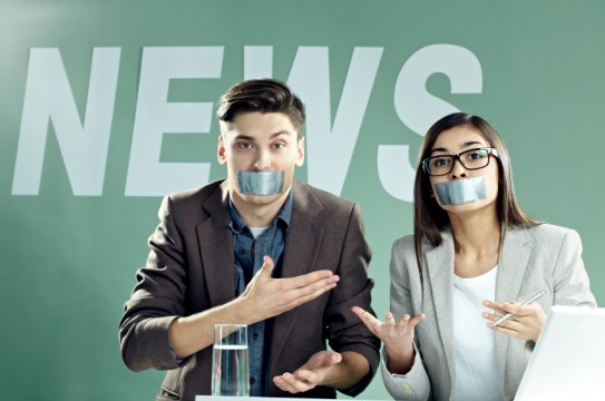 News presenters with taped mouths on TV