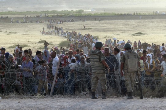 turkish-soldiers-stand-guard-syrian-refugees-wait-behind-border-fences